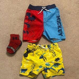 Bundle of Mickey Mouse and shark swim trunks and under Armour socks